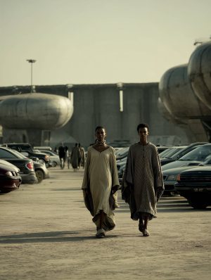 Two women walking on a desert future parking lot